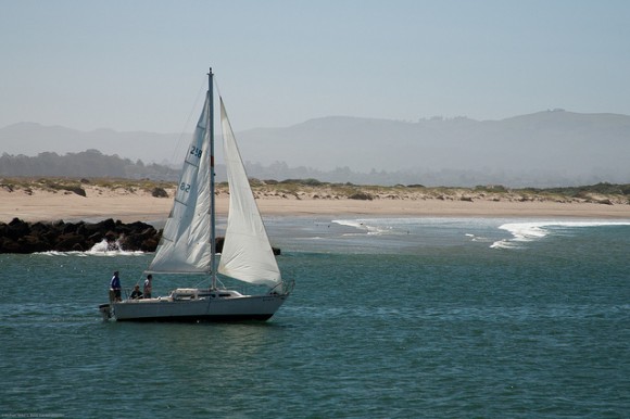 Sailboat exits Morro Bay harbor.