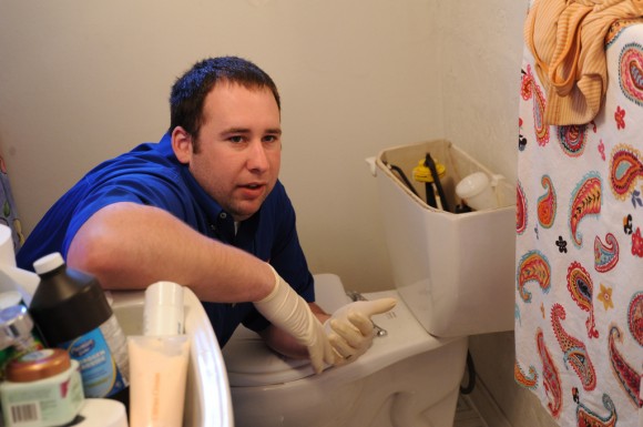 Plumber working on toilet